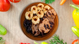Pork loin with dried plums, Silesian dumplings, and red cabbage