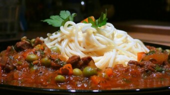 Beef goulash in tomato sauce with vegetables and noodles