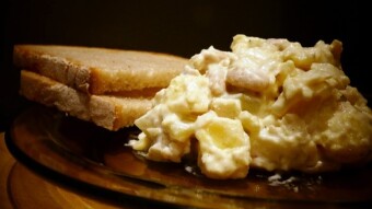Homemade herring salad with potatoes, pickled cucumber, beans, and mayonnaise