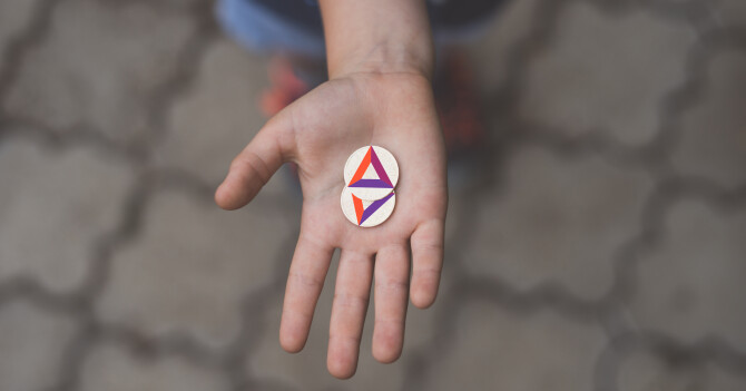 A hand offering BAT coins forward