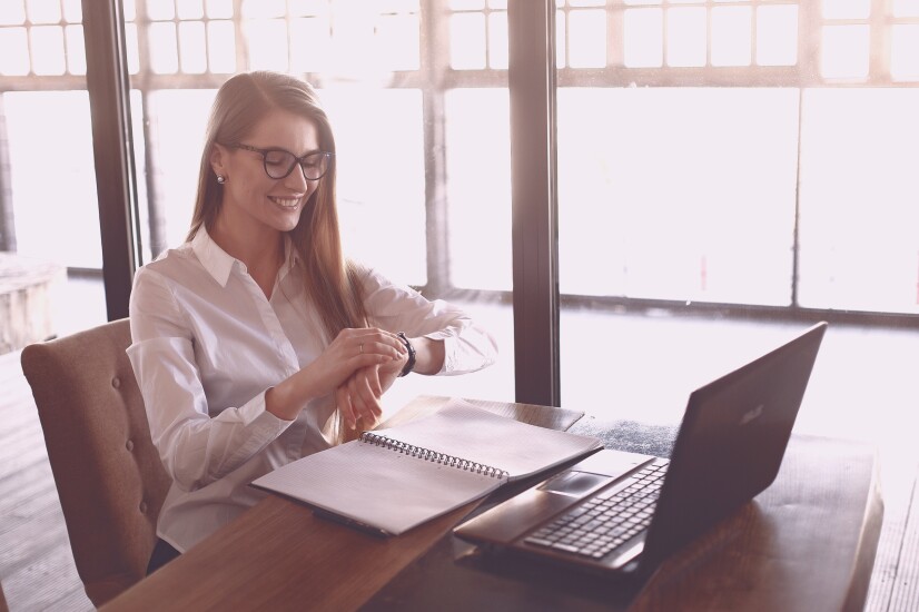 Young woman at her office checking her watch
