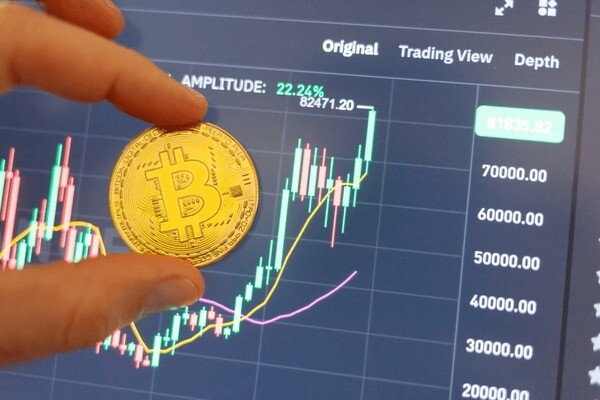 “Person sitting alone at a desk, gazing thoughtfully at a laptop displaying Bitcoin charts, reflecting quietly on emotions and market movement.”