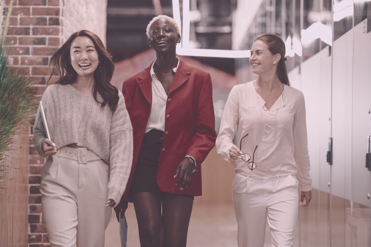 three women smiling walking confidently