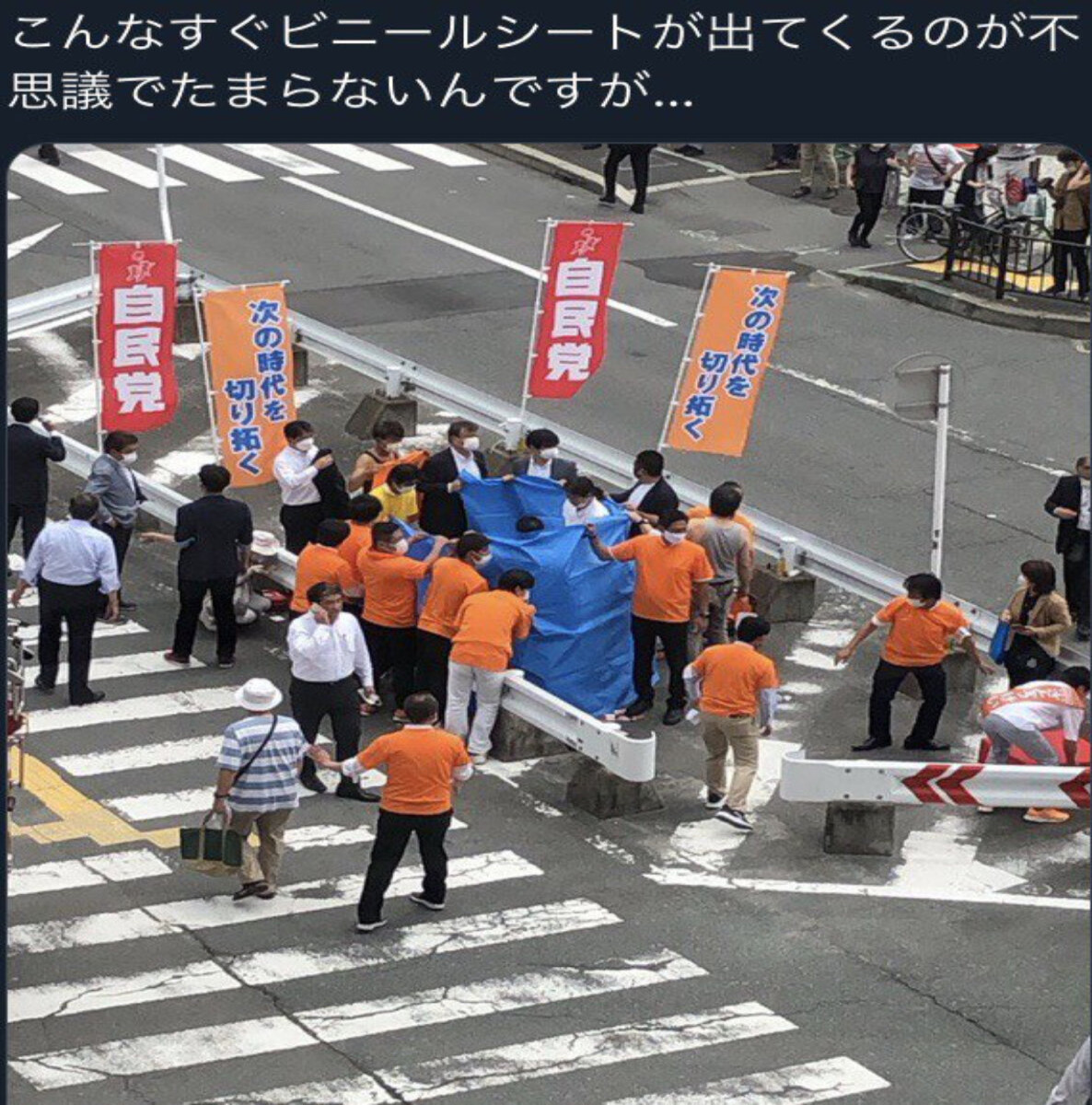 Mysterious blue sheet inside strange guardrail formation. Who are the orange coats?