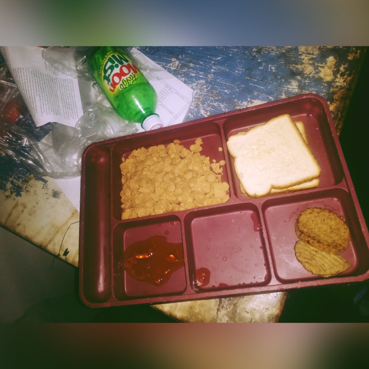 Picture of tray with cereal, toast, jelly, and 2 sausages in each of the 5 slots.