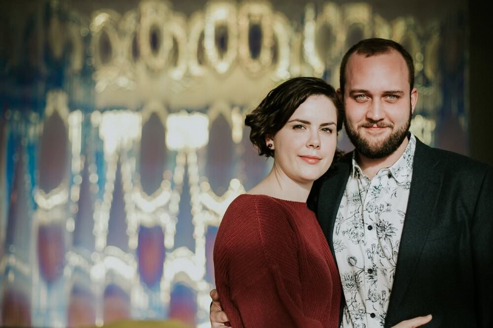 couple hugging in front of art in alexander hotel