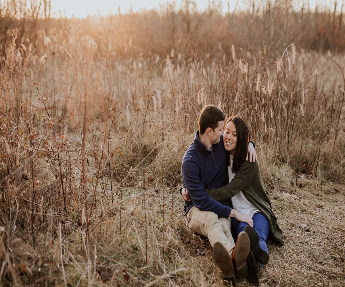 couple sitting in field in noblesville