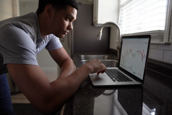 man trading cryptocurrency on laptop