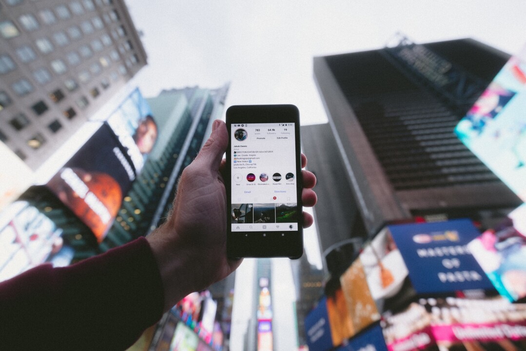 Person holding up phone, checking their Instagram profile