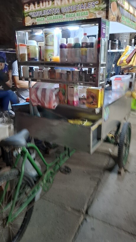 Realistic photo of a customer paying at a Peruvian emoliente stand with a smartphone crypto wallet, contactless tap next to a steaming glass of emoliente
