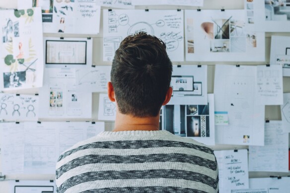 a man looking at different charts and documents hanged on the wall