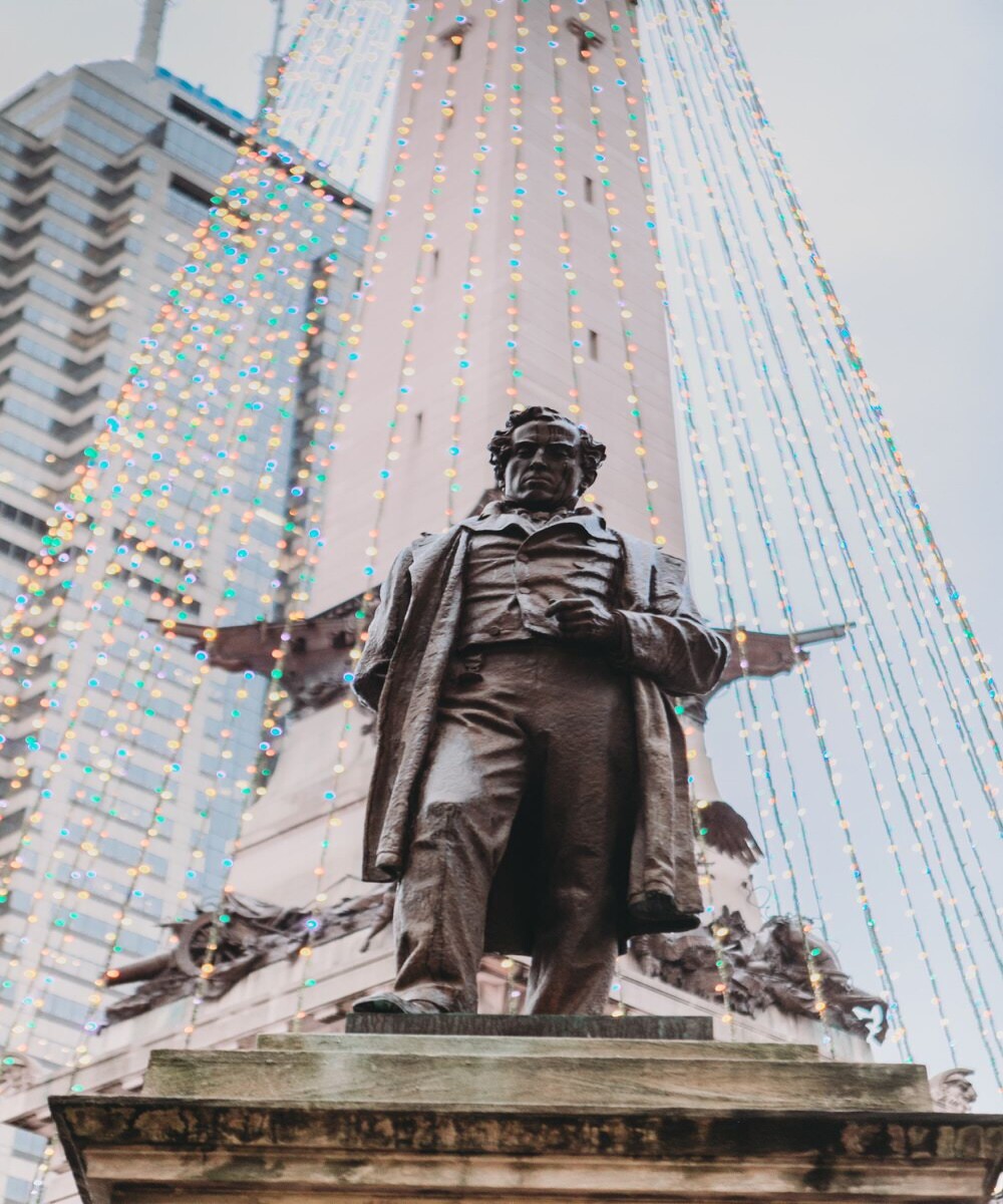 statue in front of soldiers and sailors monument in downtown indy where part of the monument looks like wings behind the statue