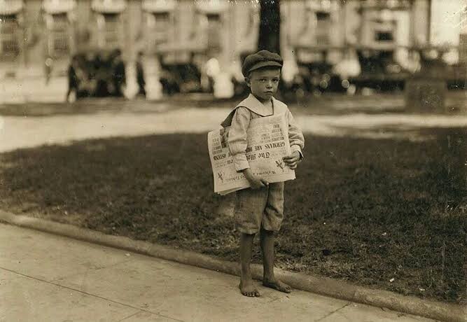 A small kid selling Newspaper