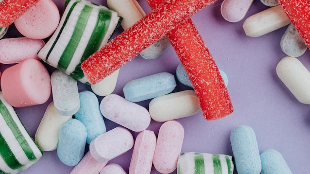 Multicoloured sweets on a lilac surface
