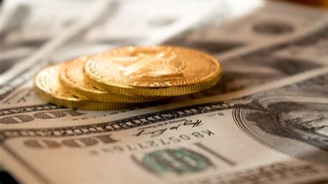 Some coins with several 100 dollar bills representing savings