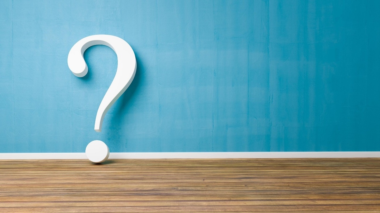 Giant Question Mark Standing Against A Blue Wall