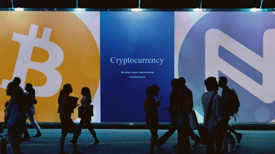 People walking past cryptocurrency signs