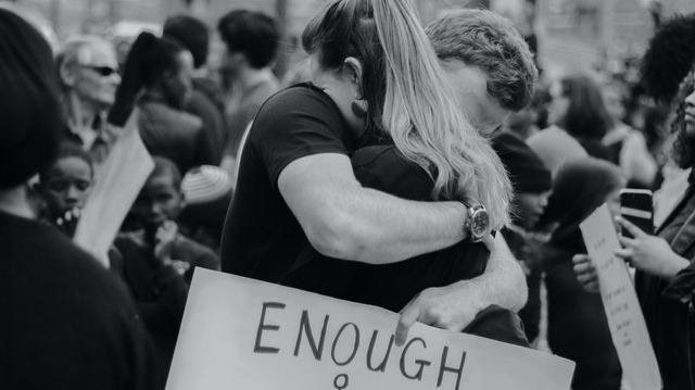 Couple hugging and holding a sign