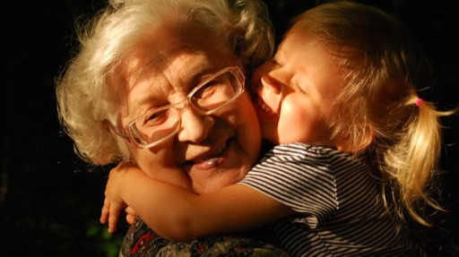 a small child hugging her grandmother