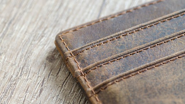 Leather card holder for a wallet, on a piece of wood