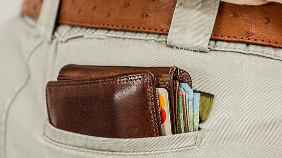 A pocket with a wallet inside of it.