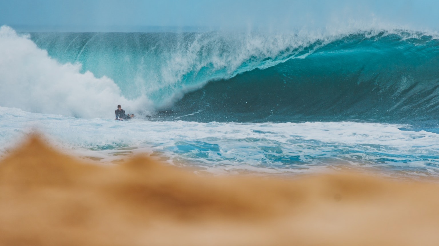 Autor fotky: Jess Loiterton: https://www.pexels.com/sk-sk/photo/surfovanie-selektivne-zaostrenie-more-plaz-8651081/