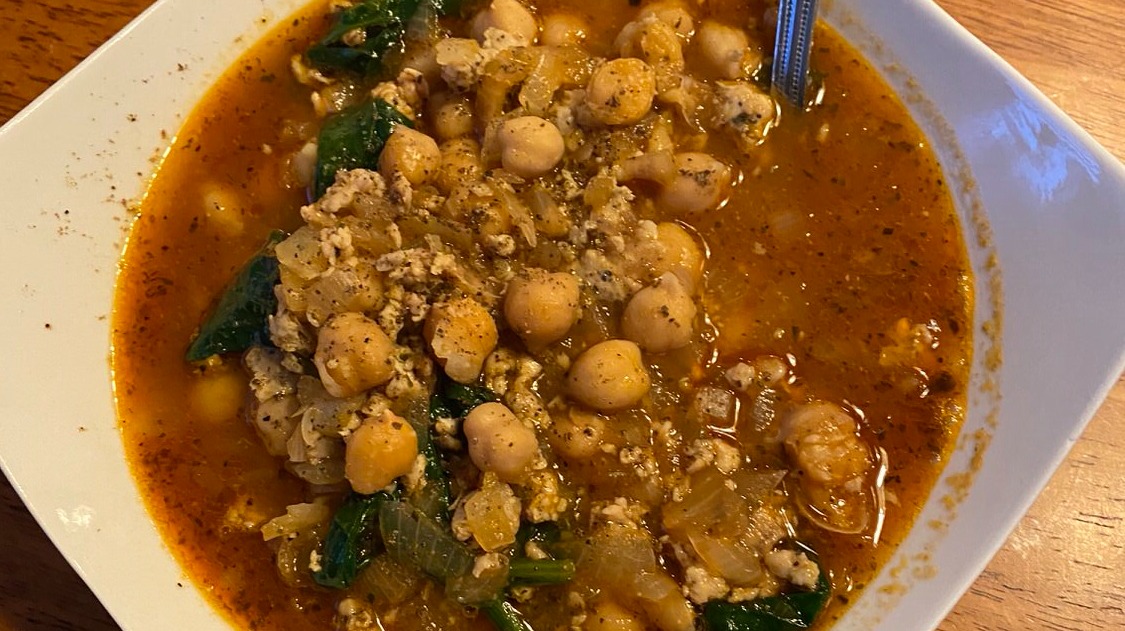 chicken soup with chickpeas and spinach in it