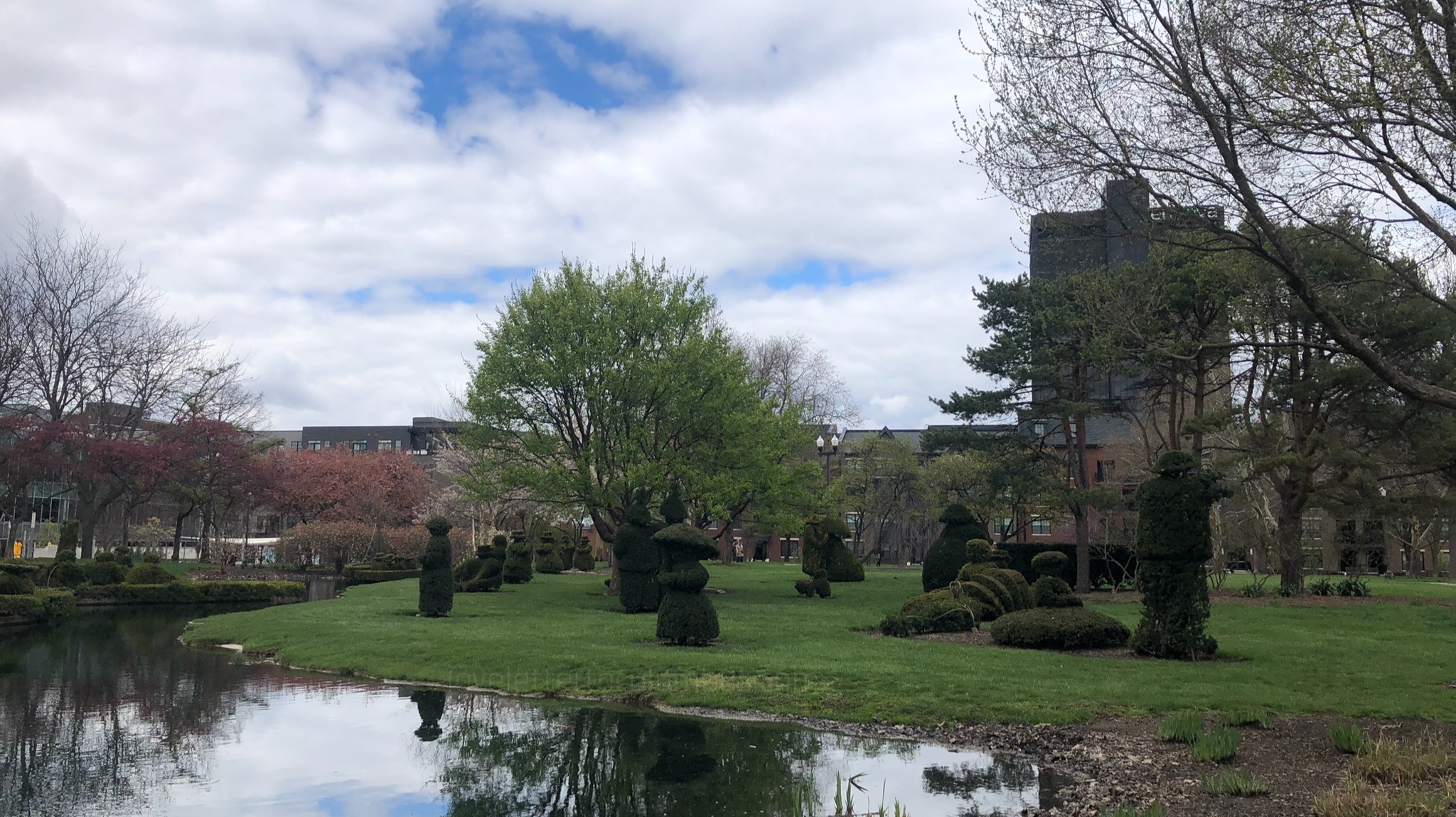 Figures facing pond at Topiary Park
