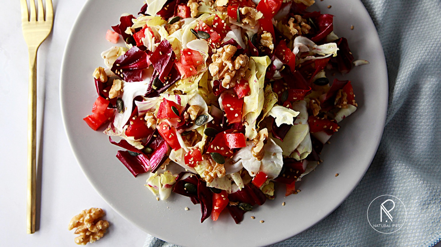 Salad with red and variegated radicchio, tomato, walnuts, pumpkin and sesame seeds.