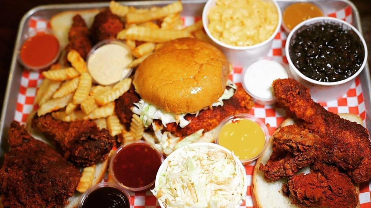 A meal from Al's Hot Chicken, featuring a Nashville hot chicken sandwich and several side dishes