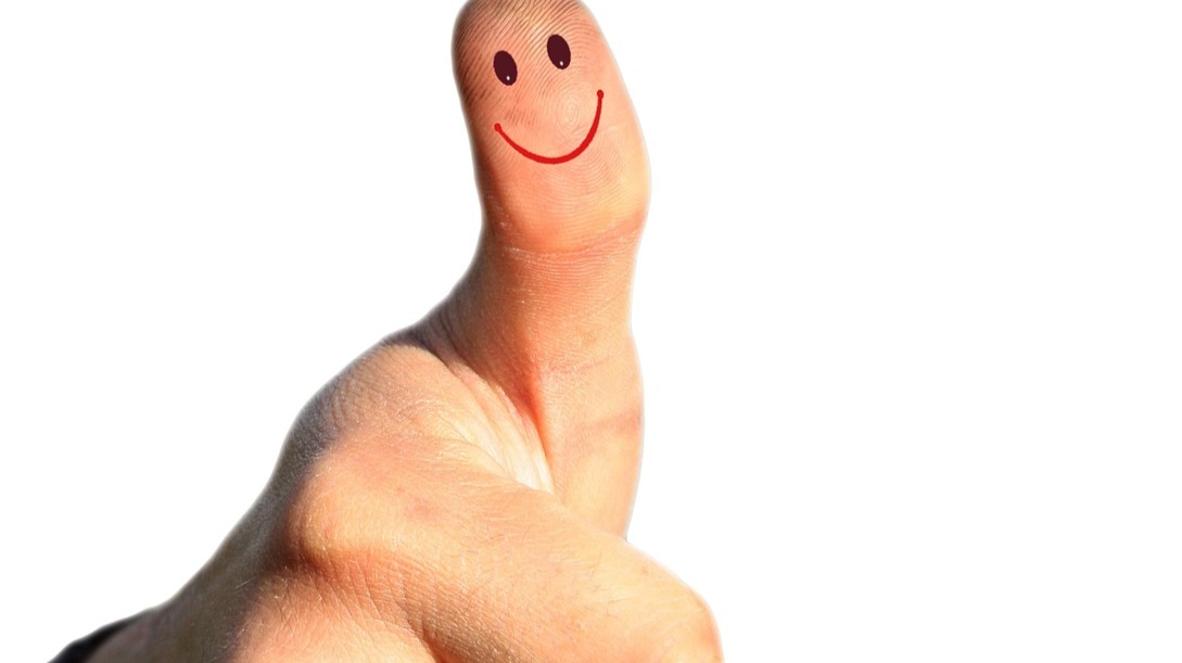 thumb up with drawn smiled faceon it