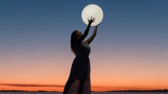 Woman grabbing moon