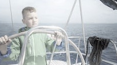 boy steering sailboat